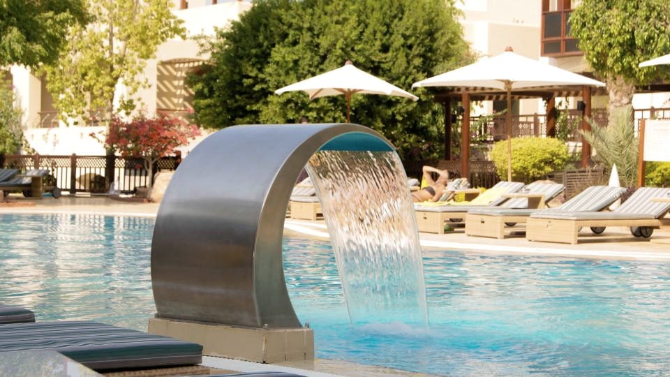Curved hydrotherapy cascade pouring into a pool