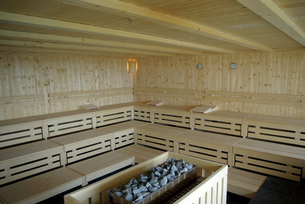 Sauna heater filled with stones, set below the lower bench