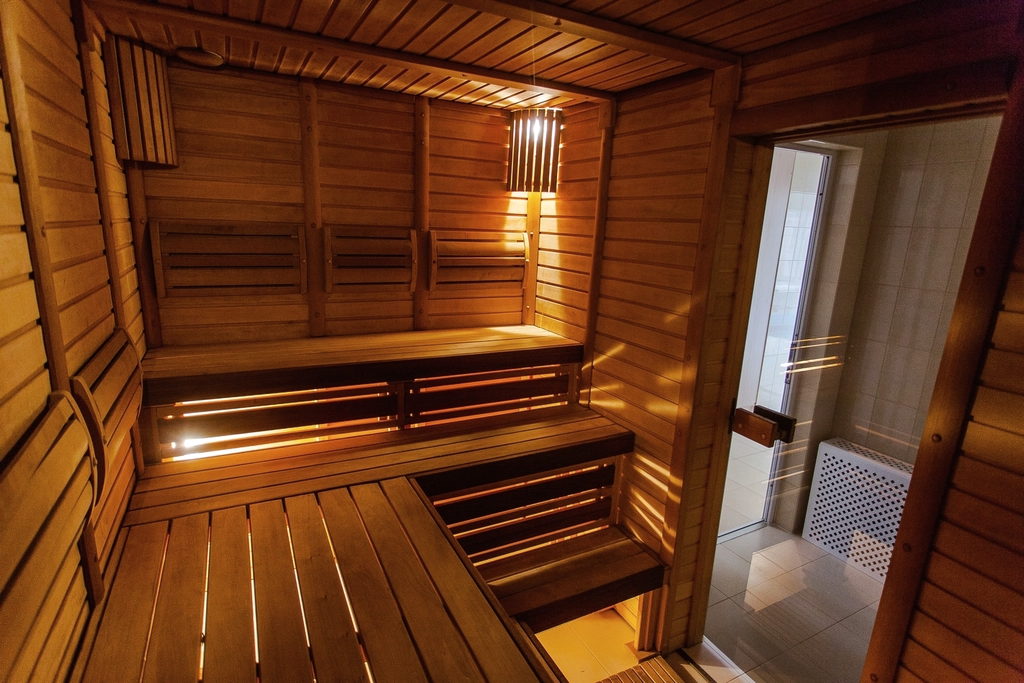 Warm timber sauna with tiered benches and a lit doorway