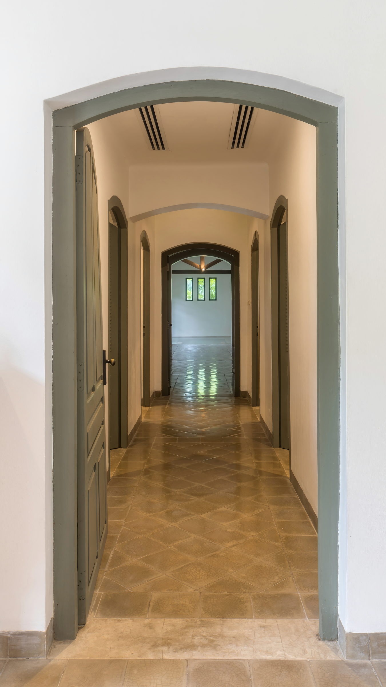 Narrow corridor with an arched opening leading to a spa pool